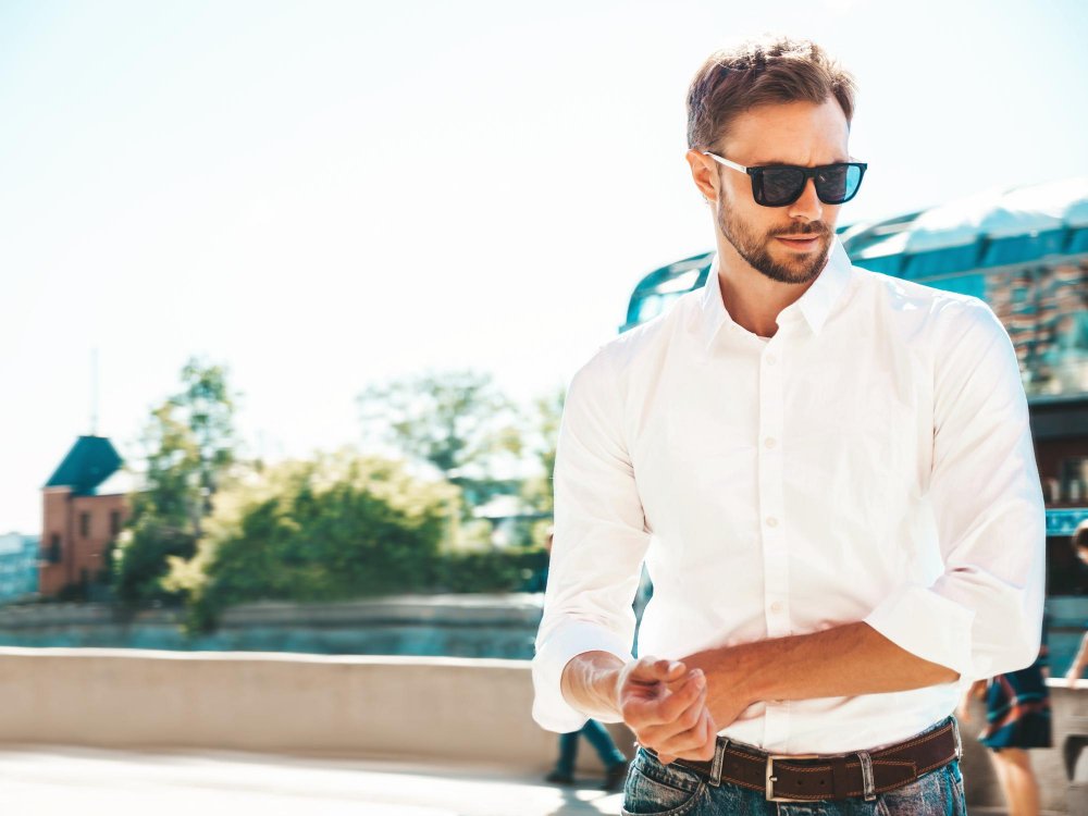 portrait handsome smiling stylish hipster lambersexual modelmodern man dressed white shirt fashion male posing street background sunglasses outdoors sunset