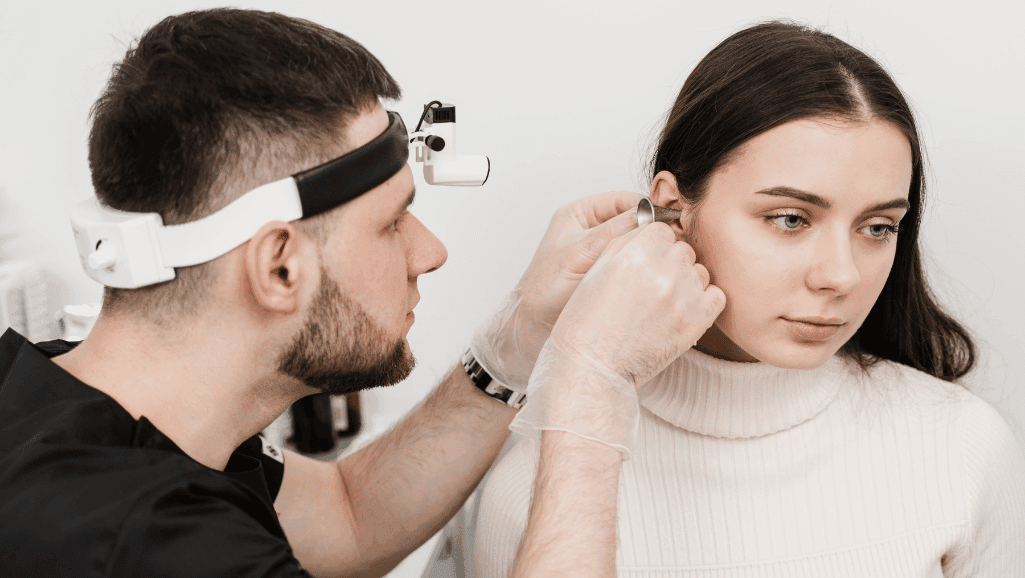 Expert examining girl as ear for infection
